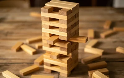 Wooden Jenga tower with blocks pulled and scattered on a wooden table